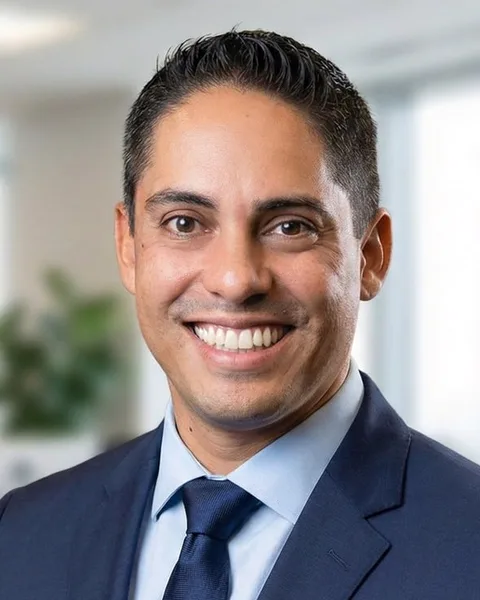 Retrato de Anderson Trinca, de terno azul, sorrindo